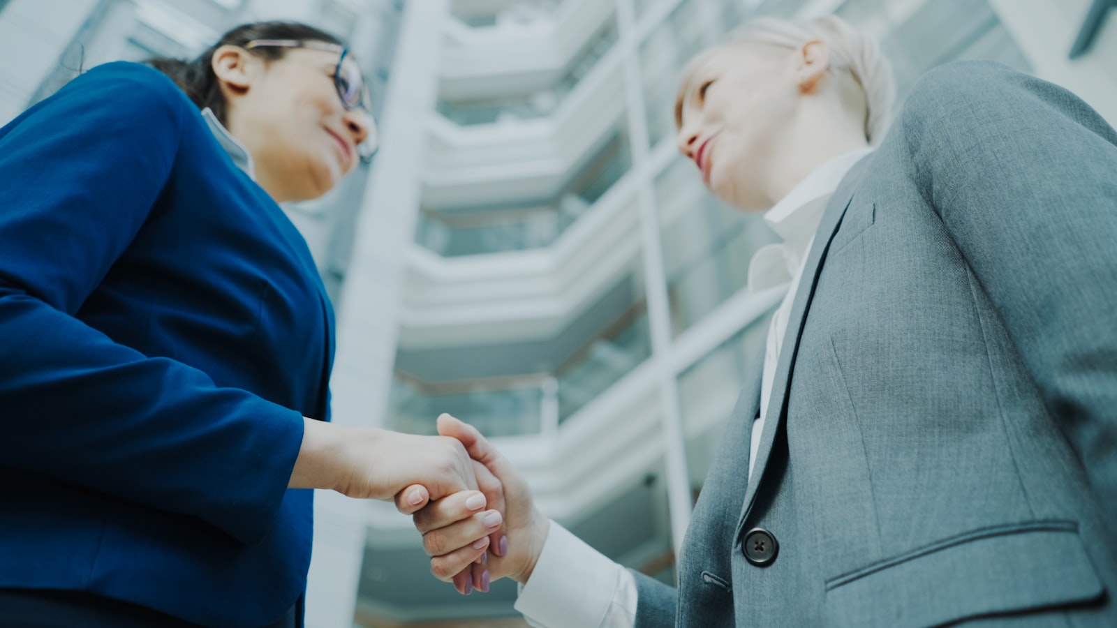 Two people shaking hands in a modern office